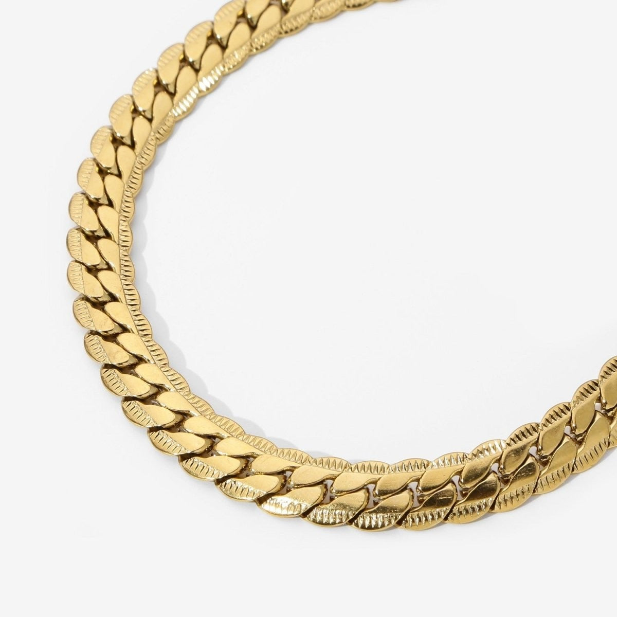 Aramat Jewels platte gourmet ketting van 6mm breed goudkleurig staal met een unieke bewerkte rand.