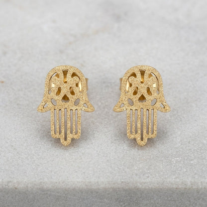 Aramat Jewels goudkleurige Hamsa oorstekers van RVS met een matte sandblasted afwerking in de vorm van een handje.