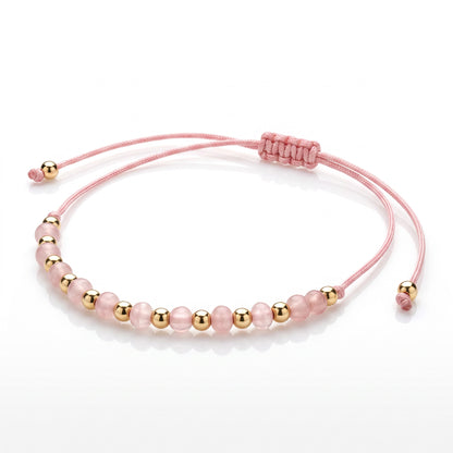 Aramat Jewels roze enkelbandje met 5mm cats eye kralen en goudkleurige accenten, verstelbaar met schuifknoop.