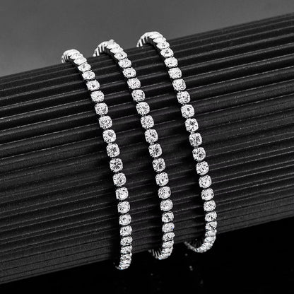 Aramat Jewels zilverkleurige stalen tennisarmband met fonkelende 4mm zirkonia stenen op een zwarte displayhouder.