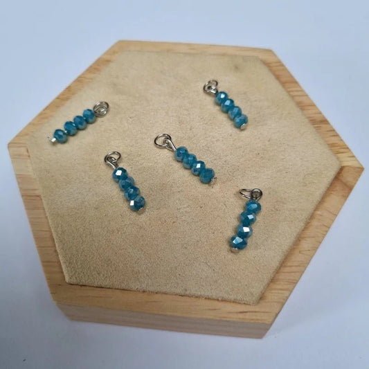Een paar blauwe glaskralen en zilveren oorkettingen